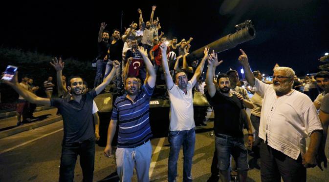 Sejumlah warga menguasai tank di Bandara Internasional Ataturk, Istanbul, Turki, (16/7). Aksi warga tersebut guna menolak aksi kudeta yang dilakukan militer Turki. (REUTERS/Huseyin Aldemir)