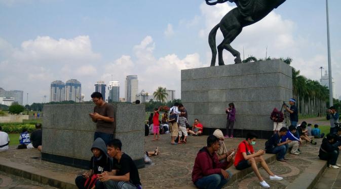 Gamer memadati area depan patung Pangeran Diponegoro di Monas mencari monster Pokemon (Liputan6.com/ Sulung Lahitani M.)