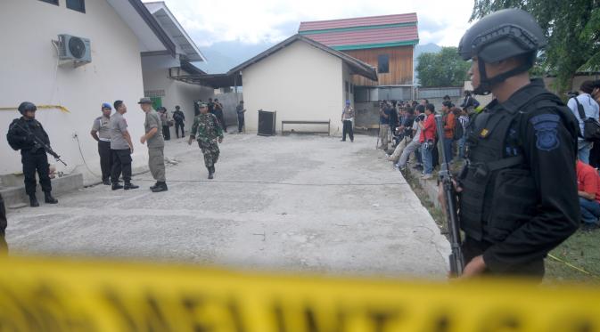 Sejumlah polisi bersenjata disiagakan disekitar RS Bhayangkara Palu, Sulawesi Tengah, Selasa (17/7). Dua jenazah diduga teroris Santoso alias Abu Warda dan Muhtar yang tewas dalam baku tembak tiba di RS tersebut untuk diidentifikasi. (OLAGONDRONK/AFP)