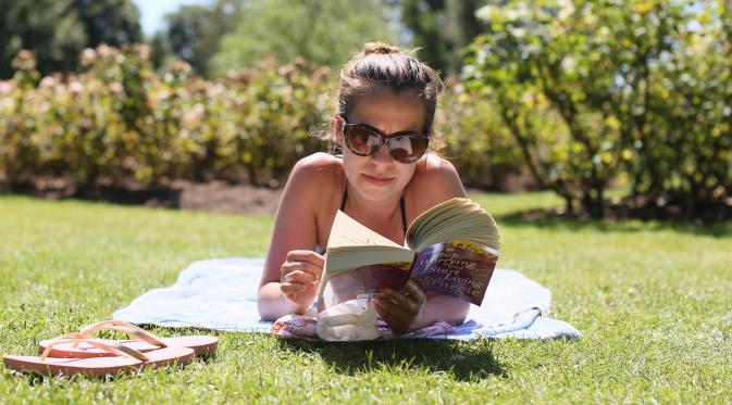 Seorang wanita berjemur sambil membaca buku di di Regents Park, London, Inggris, Selasa (19/7). Panas yang mencapai suhu 35 derajat celcius menjadikan bulan Juli sebagai rekor bulan terpanas bagi warga Inggris (REUTERS/Neil Hall)