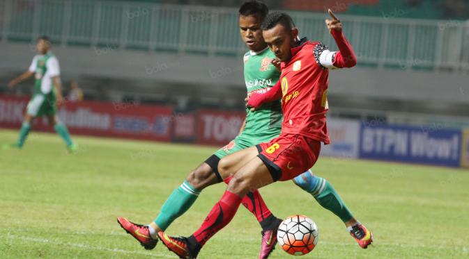 Pemain PS TNI, Manahati Lestusen (kiri) berebut bola dengan pemain Barito Putra, Rizky Pora di Stadion Pakansari, Bogor, Jumat (22/7/2016). (Bola.com/Nicklas Hanoatubun)