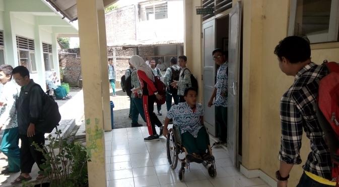Edi Priyanto, siswa kelas 9 SMP 2 Sewon, Bantul, setiap hari berangkat ke sekolah menggunakan kursi roda sejauh enam kilometer. (Liputan6.com/Fathi Mahmud)