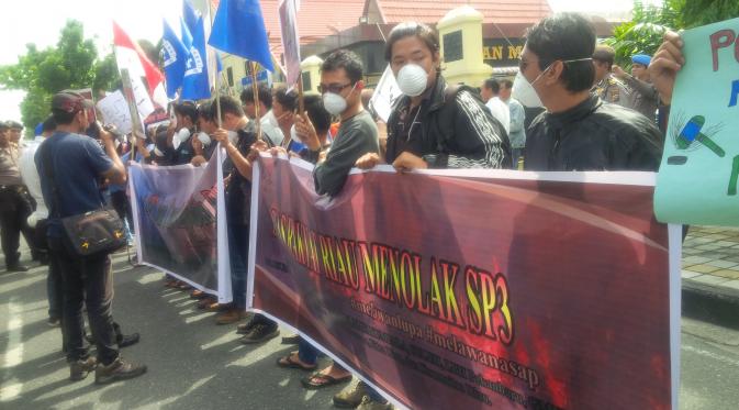 Walhi bersama mahasiswa dari GMKI menggelar demonstrasi di Mapolda Riau untuk mendesak kasus SP3 dibuka kembali dan menyeret perusahaan pembakar lahan. (LIputan6.com/M Syukur)