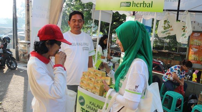 Pengunjung Pasar Cijantung mengunjungi booth Tolak Linu dan menunjukkan kantong daur ulang (recycle bag).