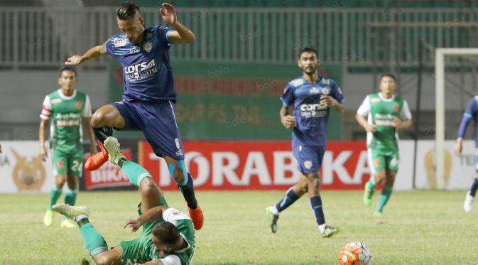 Pemain Arema Cronus, Raphael Maitimo (atas) berebut bola dengan pemain PS TNI, Wawan Febriyanto  pada laga Torabika SC 2016 di Stadion Pakansari, Bogor, Minggu (31/7/2016). (Bola.com/Nicklas Hanoatubun)