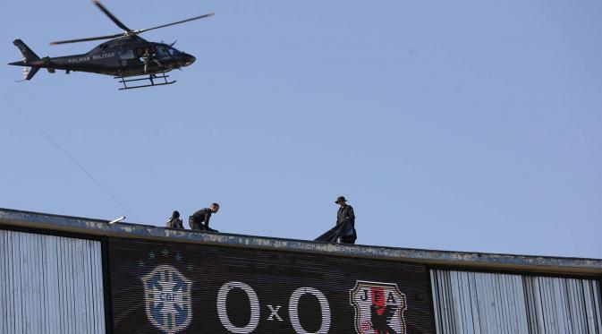 Sebuah helikopter melakukan pengawasan saat laga ujicoba jelang Olimpiade 2016 Rio Janeiro antara Brasil melawan Jepang di Goiania, Brasil, Minggu (30/7/2016). Penjagaan dilakukan untuk antisipasi terjadinya tindak terrorisme. (AP/Eraldo Peres)