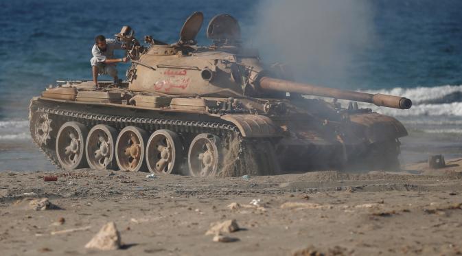 Pasukan Libya mengendarai tank T-55 usai bertempur dengan militian ISIS di Sirte, Libya, (3/8). Tentara Libya yang bersekutu dengan PBB kembali bertempur untuk merebut kembali kota Sirte dari tangan kelompok militan ISIS. (REUTERS/Goran Tomasevic)