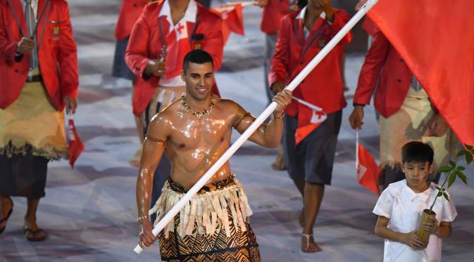 Atlet taekwondo asal Tonga, Pita Nikolas Taufatofua menarik perhatian penonton dalam defile kontingen dalam pembukaan Rio 2016, pada Sabtu (6/8/2016) di Maracana stadium, Rio de Janeiro.  OLIVIER MORIN / AFP