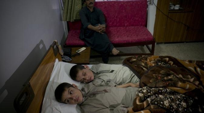 Abdul Rasheed dan Shoaib Ahmed, kakak-adik yang lumpuh ketika malam datang. (Daily Mail)