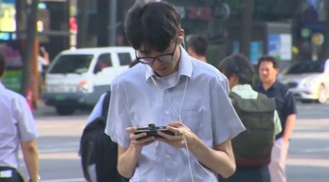 Seorang pria bermain ponsel sambil berjalan kaki (CNN)