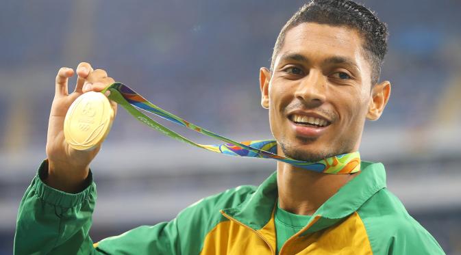 Atlet Afrika Selatan, Wayde van Niekerk, memperlihatkan medali emas Olimpiade Rio de Janeiro 2016 yang direbutnya dari cabang atletik nomor 400m. (REUTERS/Sergio Moraes)