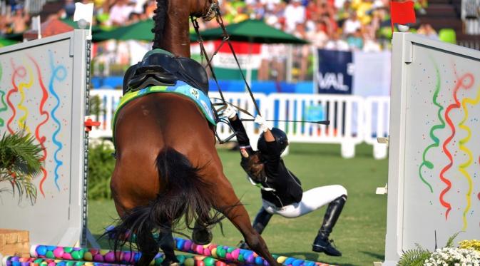  Atlet Hungaria, Zsofia Foldhazi, terjatuh dari kudanya setelah gagal melewati rintangan dalam nomor modern pentathlon wanita Olimpiade Rio 2016 di Stadion Deodoro, Rio de Janeiro, (19/8/2016). (AFP/Yashuyoshi Chiba)