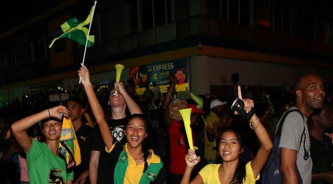 Warga Jamaika berpesta merayakan keberhasilan Usain Bolt meraih emas cabang atletik nomor lari 4x100m di Kingston, Jamaika, Sabtu (20/8/2016). (Reuters/Gilbert Bellamy)