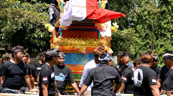 Warga membawa peti mati berisi jenazah Aipda Wayan Sudarsa, polisi korban pembunuhan pasangan bule, di Jimbaran, Bali, Minggu (21/8). Warga Desa Adat Jimbaran dan pecalang pun turut serta mengantarkan korban yang akan diaben. (SONNY Tumbelaka/AFP)