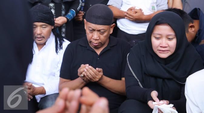 Artis komedi Tukul Arwana bersama anaknya berdoa saat pemakaman istrinya, Susiana, di TPU Tanah Kusir, Jakarta, Rabu (24/8). Susiana wafat di usia 48 tahun akibat penyakit asma yang dideritanya. (Liputan6.com/Immanuel Antonius)