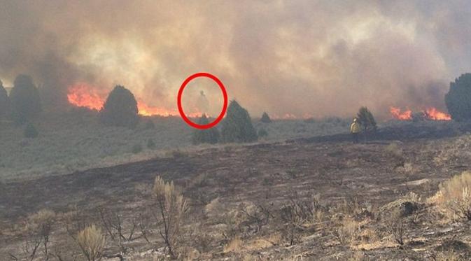 Empey mengaku melihat sosok tersebut berdiri di tengah kobaran api yang melahap lahannya. Ia lalu memutuskan untuk mengabadikannya. (@JeanetteEmpey/Dailymail.com) 