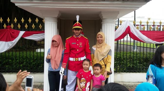 Warga selfie saat seremoni pergantian pasukan jaga Istana Kepresidenan dalam Car Free Day (CFD) di seputar Medan Merdeka Barat, Jakarta, Minggu (28/8/2016). (Delvira Hutabarat/Liputan6.com)