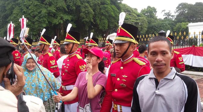 Warga selfie saat seremoni pergantian pasukan jaga Istana Kepresidenan dalam Car Free Day (CFD) di seputar Medan Merdeka Barat, Jakarta, Minggu (28/8/2016). (Delvira Hutabarat/Liputan6.com)