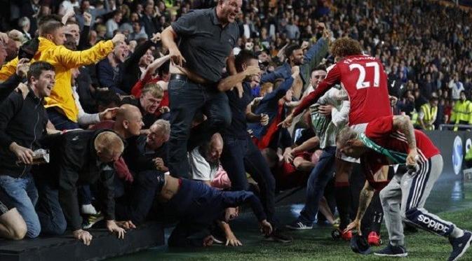 Aksi heroik Marouane Fellaini saat seorang fans terjebak di kerumunan akibat merayakan gol telat Marcus Rashford. (Reuters)