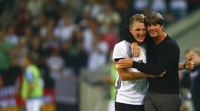 Pemain Jerman, Bastian Schweinsteiger, memeluk pelatihnya Joachim Loew usai laga melawan Finlandia di Stadion Borussia-Park, Jerman, Kamis (1/9/2016). Pertandingan ini merupakan laga terakhir Bastian berseragam Jerman. (Reuters/Wolfgang Rattay)