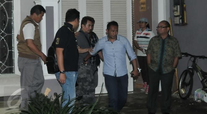 Gatot Brajamusti alias Aa Gatot keluar dari rumahnya dikawal petugas usai dilakukan pemeriksaan atas rumahnya di kawasan Pondok Pinang, Jakarta, Kamis (1/9). (Liputan6.com/Yoppy Renato)