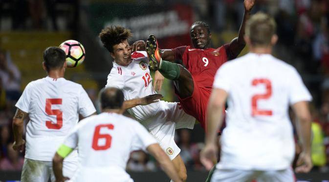Pemain Portugal Eder berjibaku melawan hadangan pemain Giblatar dalam laga ujicoba. (MIGUEL RIOPA / AFP)