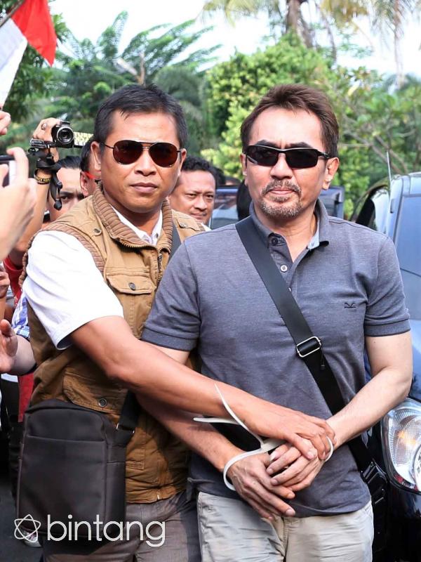 Gatot Brajamusti didampingi petugas saat diterbangkan dari Mataram menuju Jakarta untuk proses penyidikan. (Nurwahyunan/Bintang.com)