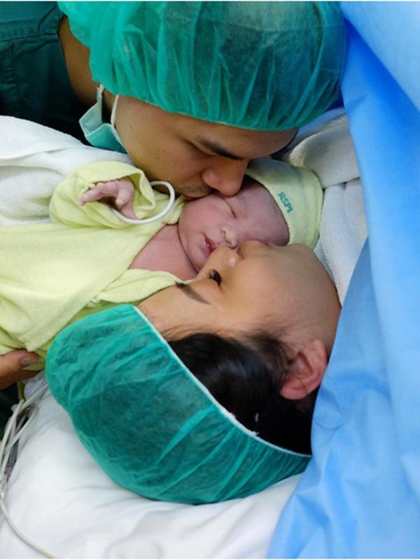 Glenn Alinskie dan Chelsea Olivia mencium mesra bayi mereka yang baru lahir, Nastusha Olivia Alinskie. (Instagram)