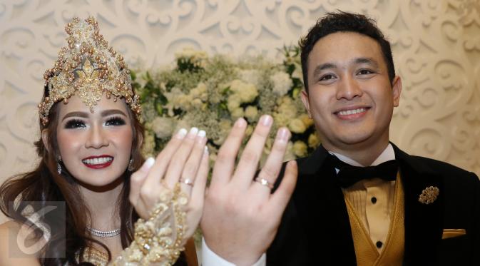 Gilang Dirga dan sang istri, Adiezty Fersa menunjukkan cicin nikah mereka saat jumpa pers di Kelapa Gading, Jakarta, Minggu (18/9). Akad nikah Gilang Dirga dan Adiezty digelar secara tertutup bagi media. (Liputan6.com/Herman Zakharia)