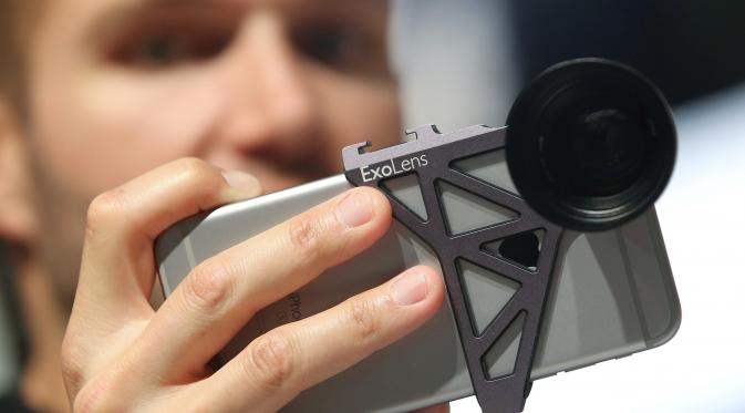 Seorang staf mengoperasikan kamera ExoLens pada sebuah ponsel saat berlangsungnya Pameran Photokina di Cologne, Jerman, (20/9). Pameran Photokina pertama diadakan di Cologne, Jerman, pada tahun 1950. (REUTERS/Fabrizio Bensch)