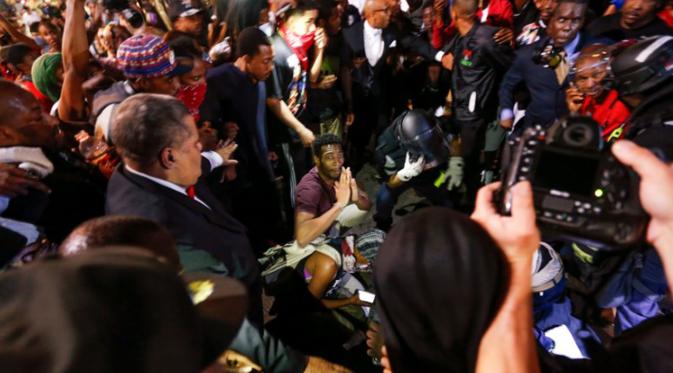 Sejumlah orang mengelilingi korban yang tertembak saat unjuk rasa di daerah Charlotte, North Carolina, AS, Rabu (21/9). Pengunjuk rasa protes atas penembakan pria kulit hitam oleh polisi. (REUTERS/Jason Miczek)