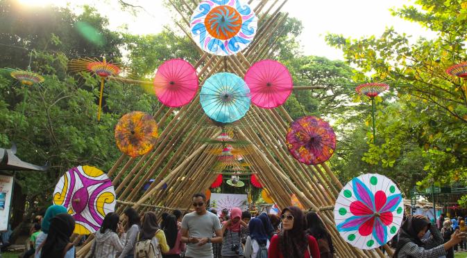 Pengunjung Festival Payung Indonesia asyik menikmati ratusan payung kain warna-warni. (Liputan6.com/Fajar Abrori)