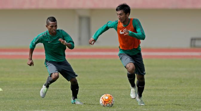 Abduh Lestaluhu coba merebut bola dari kaki Bayu Pradana pada sesi latihan Timnas Indonesia di Stadion Manahan Solo Jawa Tengah, Minggu (25/9/2016).  (Bola.com/Peksi Cahyo)