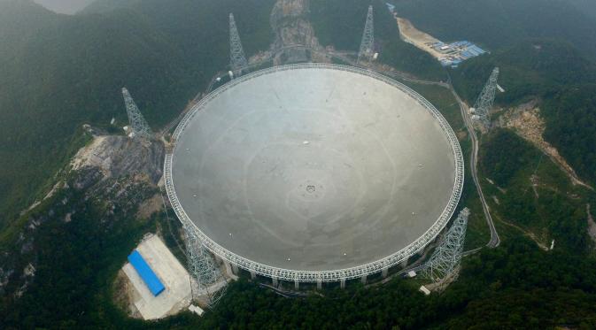 Teleskop Radio terbesar di dunia, Aperture Spherical Telescope atau FAST, terlihat pada hari pertama uji coba di Pingtang, Guizhou, China, Minggu (25/9). Berdiameter 500 meter, teleskop raksasa itu digunakan untuk mendeteksi keberadaan alien. (STR/AFP)