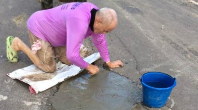 Peter Goman, mendapat banyak pujian di media sosial setelah dirinya memutuskan untuk memperbaiki jalan di dekat rumahnya di Provinsi Buriram (Facebook/Kusuma Namwong)