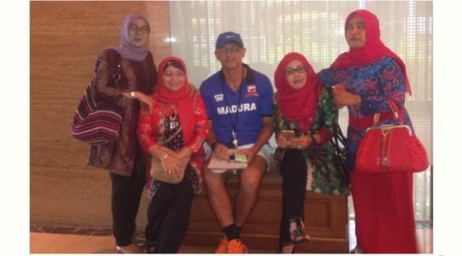 Pelatih Madura United, Gomes de Oliveira, melayani permintaan foto dari fans kalangan kaum ibu dengan senang hati. (Bola.com/Fahrizal Arnas)