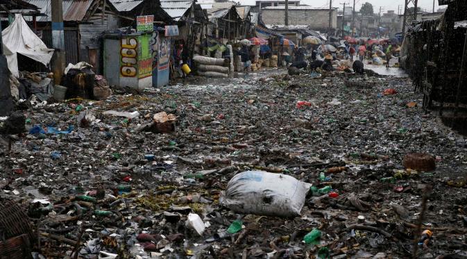 Sejumlah warga membersihkan jalan yang tertutup sampah usai Badai Matthew menghantam Port-au-Prince di Haiti (4/10). Keganasan Badai Matthew ini telah meluluhlantakkan wilayah Haiti. (REUTERS/Carlos Garcia Rawlins)