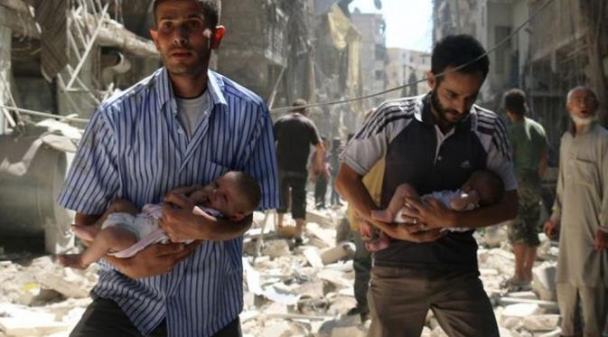 Lelaki menggendong bayi selepas serangan terjadi di Aleppo. (Mirror)
