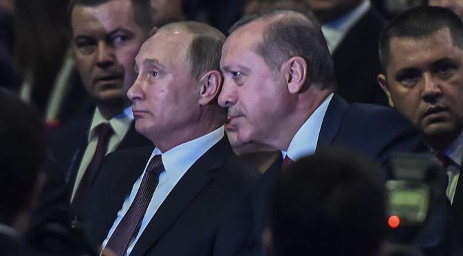 Presiden Turki Recep Tayyip Erdogan berbincang dengan Presiden Rusia Vladimir Putin saat menghadiri 23rd World Energy Conress, Istanbul, Turki (10/10). Putin dan Erdogan akan melakukan normalisasi hubungan negara yang sempat tegang. (AFP PHOTO/Ozan Kose)