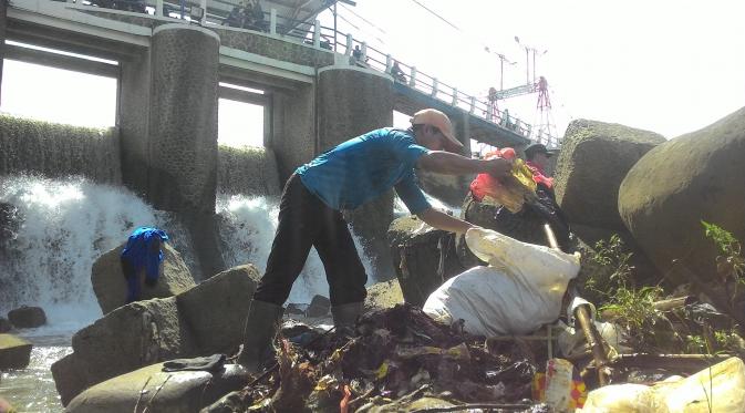Warga berjibaku dengan petugas jaga membersihkan Bendung Katulampa dari sampah. (Liputan6.com/Achmad Sudarno)
