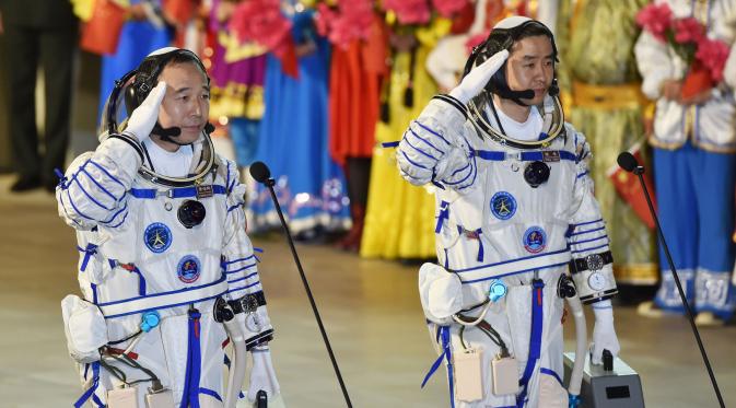 Astronot Cina, Jing Haipeng (kiri) dan Chen Dong memberi hormat sebelum peluncuran pesawat ruang angkasa berawak Shenzhou-11, di Jiuquan, Tiongkok, (17/10). Astronot tersebut akan tinggal di stasiun luar angkasa selama 30 hari. (China Daily/via REUTERS)