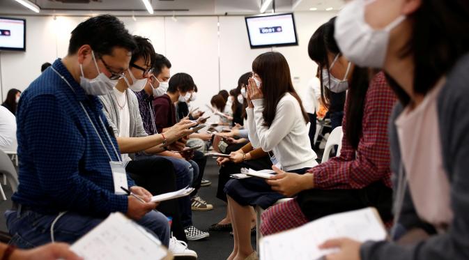 Para peserta dan wanita berbincang saat mengikuti acara layanan kencan di Tokyo, Jepang, (16/10). Dibuatnya acara Layanan kencan yang Sedang Marak di Jepang ini diakibatkan menurunnya tingkat pernikahan yang mencapai 50 Persen. (REUTERS/Kim Kyung-Hoon)