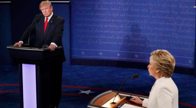 Donald Trump menyimak pemaparan Capres AS dari Partai Demokrat, Hillary Clinton saat debat capres AS ketiga dan terakhir di University of Nevada, Las Vegas, Rabu (19/10). (REUTERS/Mark Ralston/Pool)