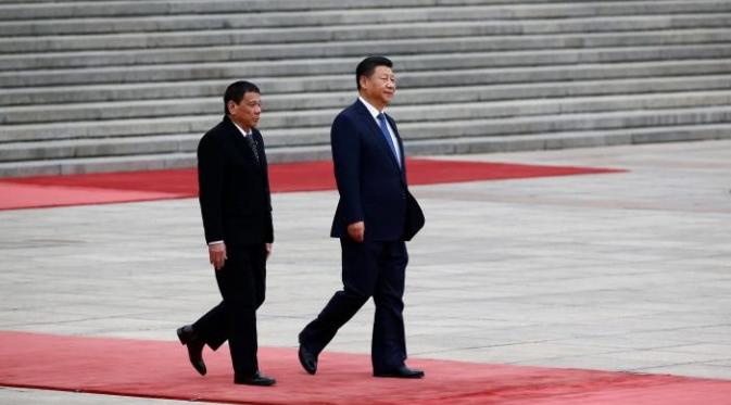Duterte berjalan bersama dengan Xi Jinping dalam pertemuan keduanya di Beijing, China (Reuters)