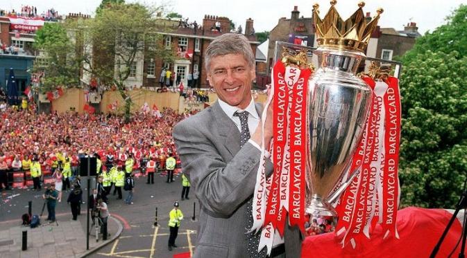 Arsene Wenger memamerkan trofi Liga Inggris yang dimenangkan Arsenal pada 2003/2004. (ESPN)