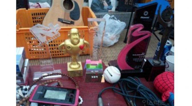 Piala penghargaan yang didapatkan MBLAQ dalam acara musik terlihat di antara barang yang dijual di pasar loak (Nate)