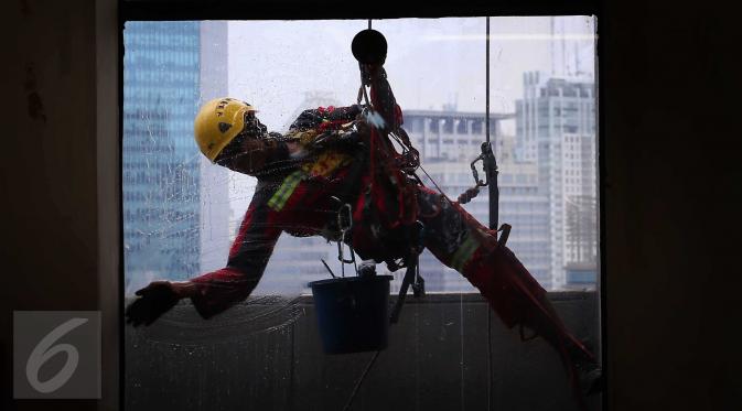 Dibantu beberapa asistennya, Sabar membersihkan setiap inci kaca yang tertempel pada gedung dengan ketinggian 36 lantai di kawasan ibu kota Jakarta. (Liputan6.com/Angga Yuniar)
