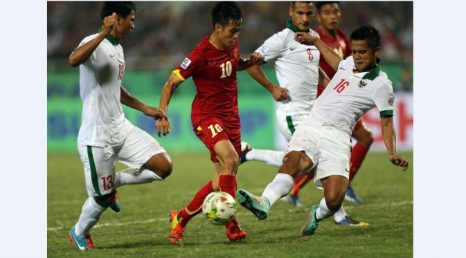 Bek Timnas Indonesia, M. Roby, berusaha menghadang laju pemain Vietnam di penyisihan Grup A Piala AFF 2014. (AFP/STR)