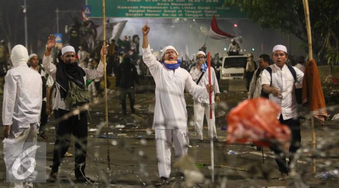 Pendemo berteriak saat polisi menyerang mereka dengan gas air mata, Jakarta, Jumat (4/11). Diduga bentrok terjadi saat massa HMI menyerang polisi dan polisi membalasnya dengan melempar gas air mata. (Liputan6.com/Immanuel Antonius)