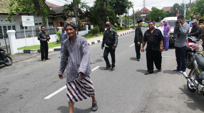 Dengan berbusana khas Jawa, Slamet Raharjo seorang warga Dusun Banjarwaru, Desa Gilangharjo, Kecamatan Pandak, Bantul, menepati nazar dengan berjalan kaki sekitar lima kilometer. (Liputan6.com/Switzy Sabandar)